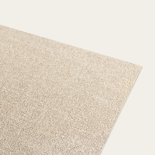 A beige, low profile rug pad made from natural rubber and handwoven jute fibers, designed to fit beneath a rug. #natural