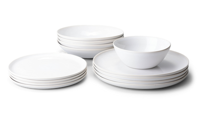 Fable white stoneware dinnerware set with stacked plates, bowls and a cereal bowl on a white background
