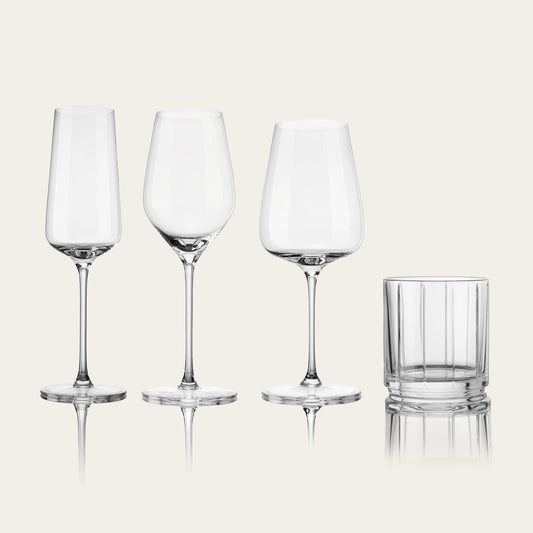 Set of four clear glassware including a highball glass on a light beige background #clear