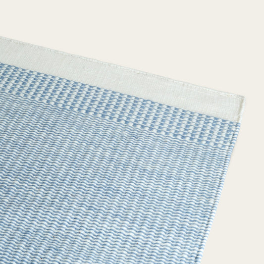 Close-up of a textured blue and white fabric with a subtle pattern on a light background #duskblue