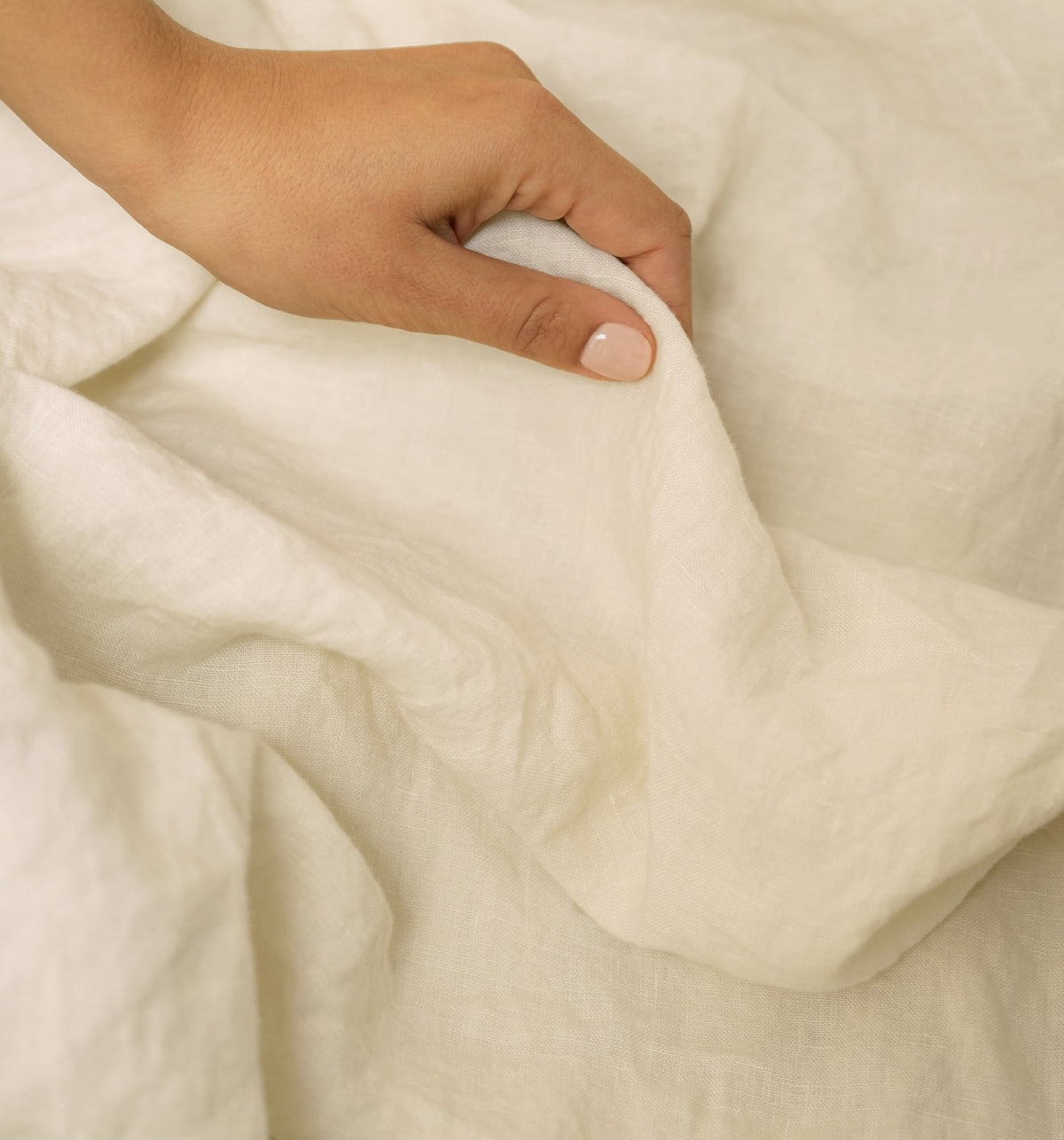 Hand on stonewashed linen bedding