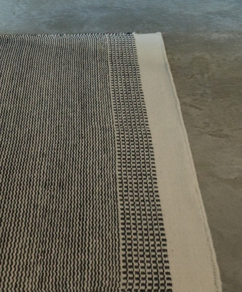 Linear Wool Rug by Fable Home, shown in Ash Black.