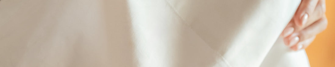 Hand lifting a crisp white percale sheet