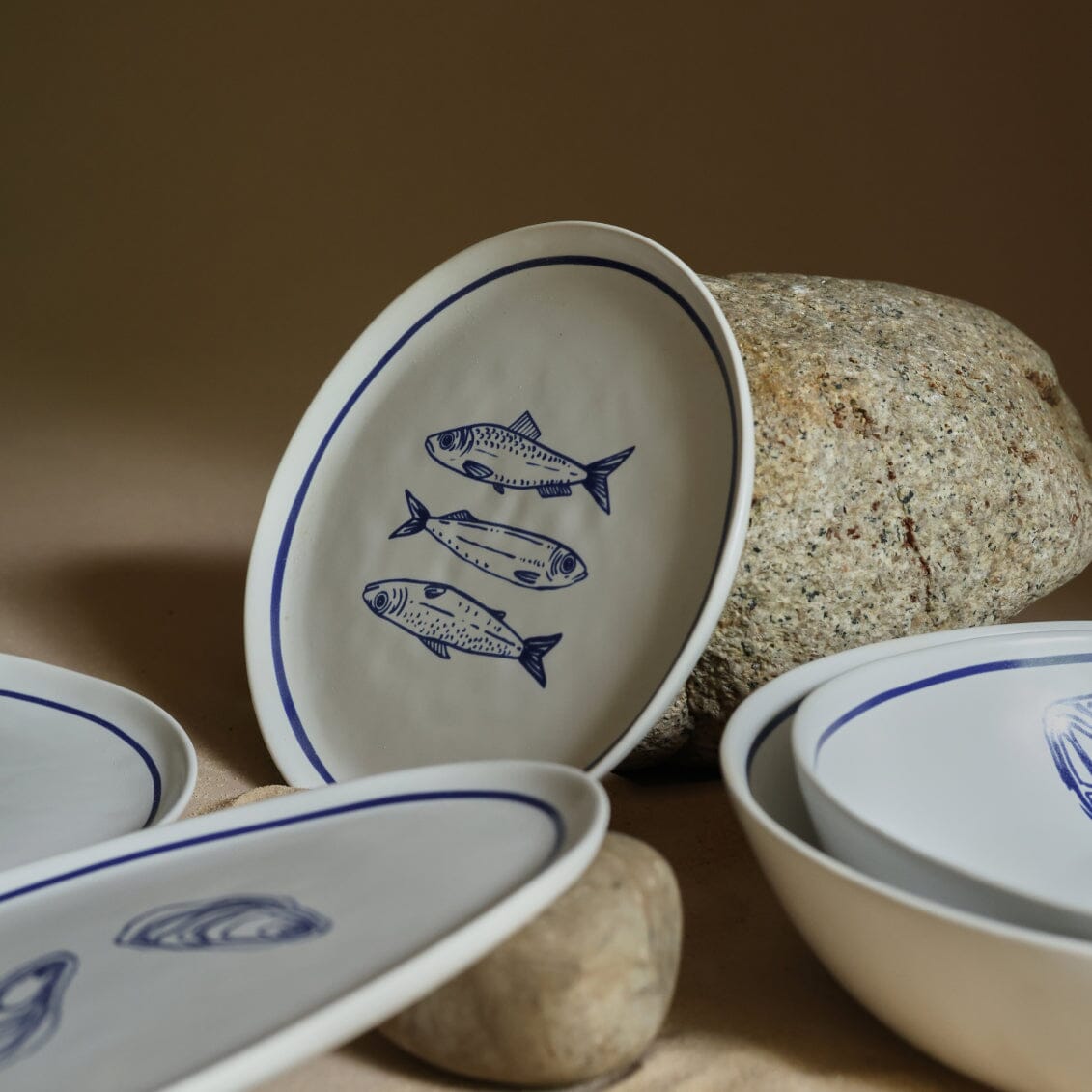 Ceramic plates with fish designs on a stone surface